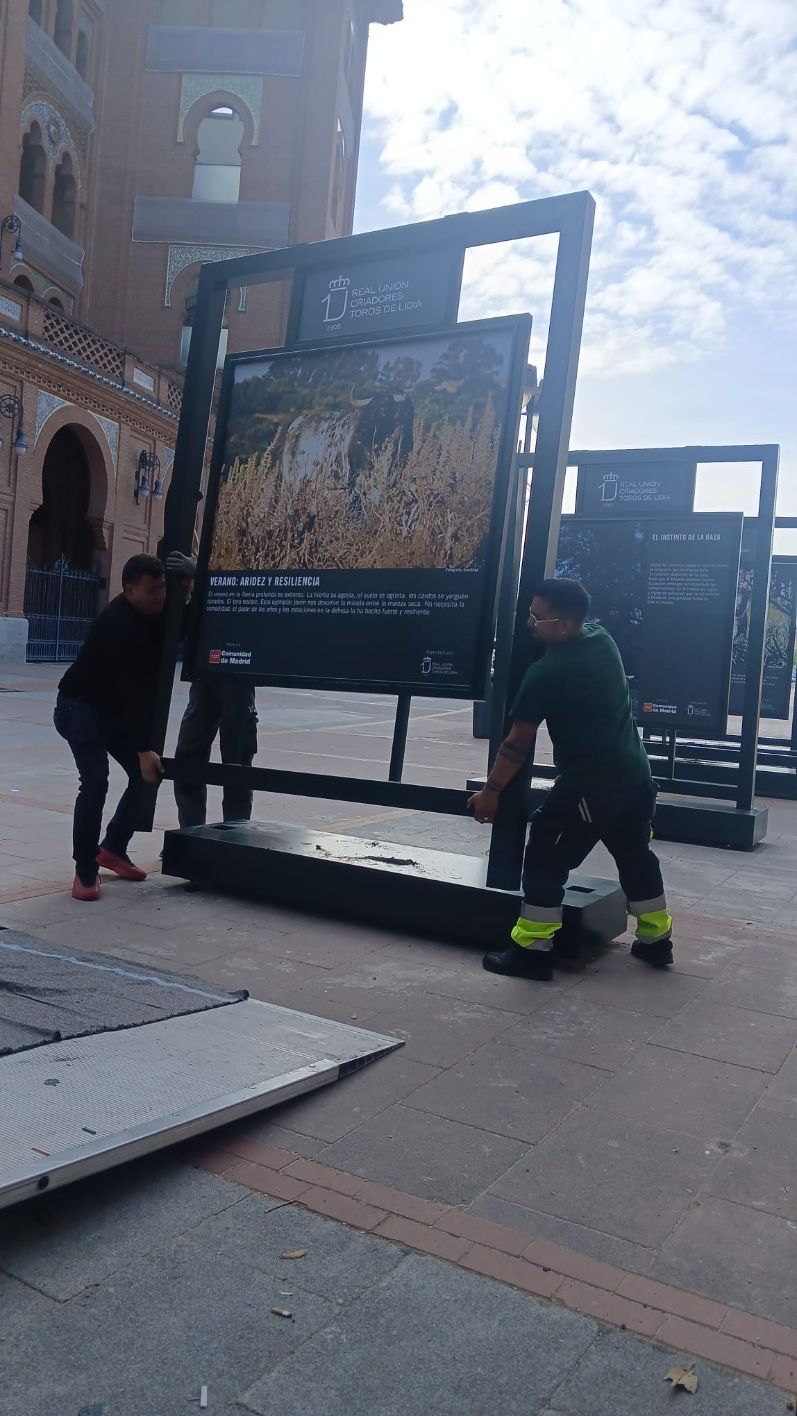 Levantando el expositor entre dos — trabajo artesanal de BullBoard